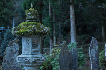 Japanese lantern covered with green moss and stones
