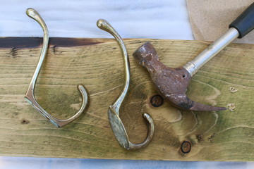 Close up of re cycled vintage pine stain wood and antique brass art deco retro clothes hooks being...