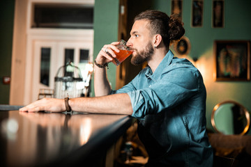Young man is holding an alcoholic cocktail