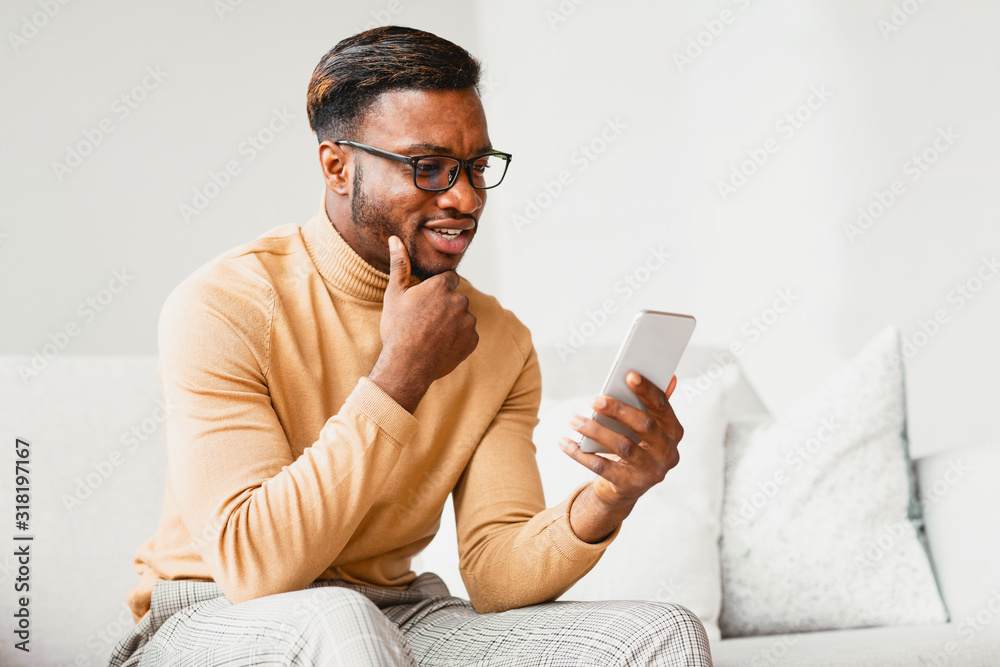 Aufkleber Man Using Phone Browsing Internet Sitting On Couch At Home