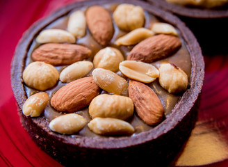 Chocolate cookies with almond nuts on a red plate. Restaurant.