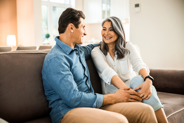 Smiling attractive lady looking at her husband in room