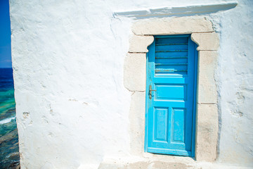 Traditional houses withe blue doors in the narrow streets of Mykonos, Greece.