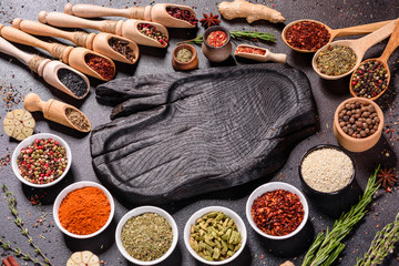 Spices and herbs over black stone background. Top view with free space for menu or recipes