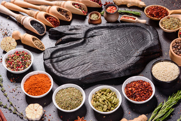 Spices and herbs over black stone background. Top view with free space for menu or recipes