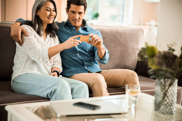 Obraz premium Smiling man and woman making online shopping at home