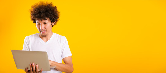 Asian handsome man with curly hair using laptop computer isolate