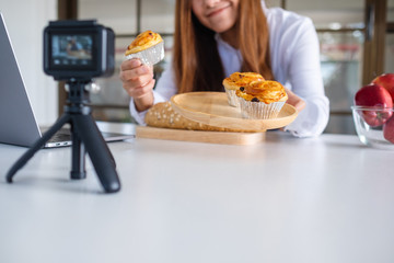 A beautiful asian woman food blogger or vlogger recording a video on camera