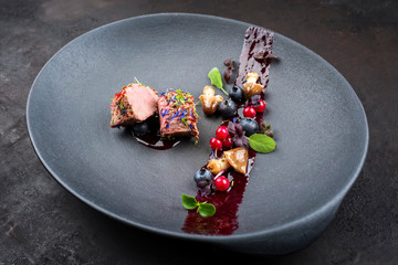 Gebratens dry aged Hirschfilet Medaillon Steak natur mit Pilzen und Waldbeeren als closeup auf...