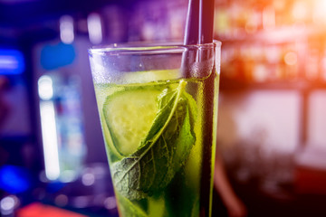 Non alcoholic cocktail with lime and mint at wooden bar counter.