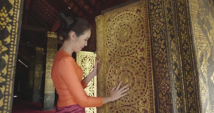 Asian Women Looking And Touching Door'S Temple