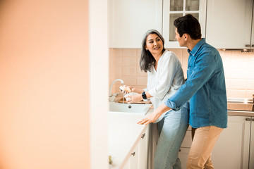 Obraz premium Pretty adult woman washing dishes at home