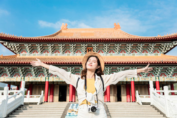 Young backpacker woman stand before traditional  chinese temple