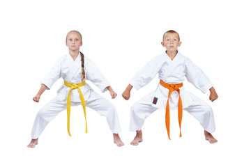 Girl and boy in karategi standing in rack kiba dachi