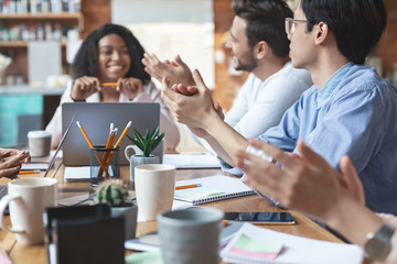 Young business team clapping hands on meeting, close up