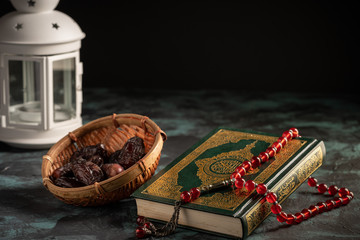 Islamic concept: The holy Quran and Tasbih (rosary beads) on dark background