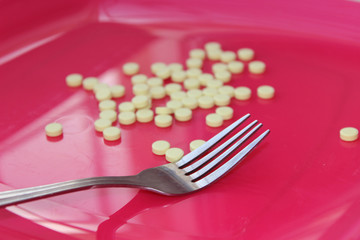 tablets on a plate with a fork