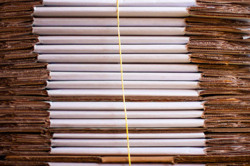 A stack of folded cardboard boxes tied with a rope