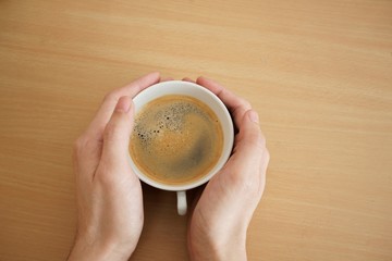 hands holding a cup of hot espresso coffee with copy space