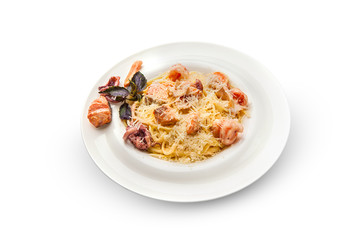 Spaghetti with shrimp, octopus, scallops and basil. Pasta with seafood on a white plate on a white isolated background.