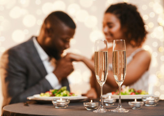 Black man and woman having romantic date at restaurant