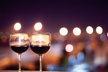 An bottle of wine and two glasses of wine on a night city lights background