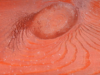 close-up of a tree knot covered with red stain