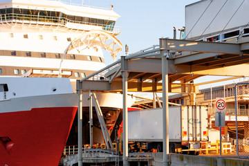 The bow of the large red ferry Spirit of Tasmania with an open cargo lock and bridge for loading with two lorries on it.