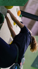girl bouldering on rocks and grips