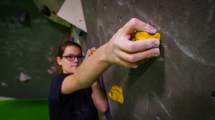 girl bouldering on rocks and grips