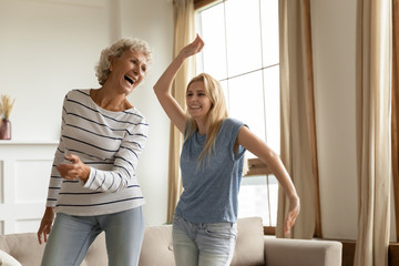Laughing sincere elderly mother having fun grown up daughter.