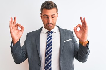 Young handsome business man wearing suit and tie over isolated background relaxed and smiling with eyes closed doing meditation gesture with fingers. Yoga concept.