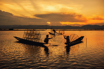 Intha Burmese fishermen on boat catching fish traditional at Inle Lake, Shan State, Myanmar
