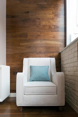 White armchair on the balcony with fashionable parquet wall decoration