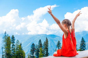 Beautiful happy little girl in mountains in the background of fog © travnikovstudio