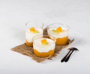 Vanilla Panna cotta in a glass Cup, Italian dessert creamy jelly with a tangerine layer, decorated...