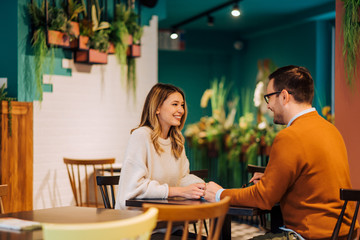 Fototapeta premium Young couple talking in the cafe.