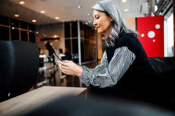 Pleased woman reading messages and smiling stock photo