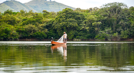 Fototapeta na wymiar man fishing with a net on a boat