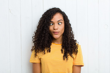 young latin woman looking goofy and funny with a silly cross-eyed expression, joking and fooling...