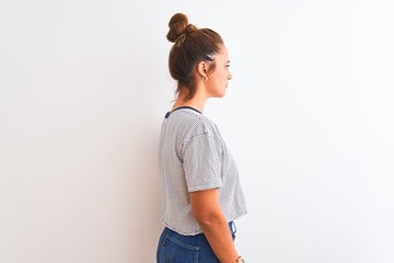 Young redhead modern woman wearing a bun over isolated background looking to side, relax profile pose with natural face with confident smile.