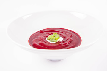 Beetroot cream soup decorated with coriander leaf and some cream
