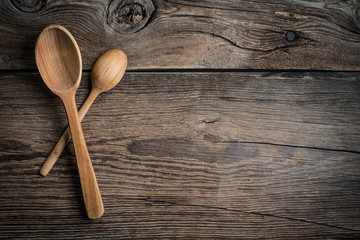 Wooden kitchen utensils on a wooden background. Copy space. Top view.