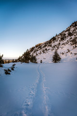 Winter mountain trail path running through the valley