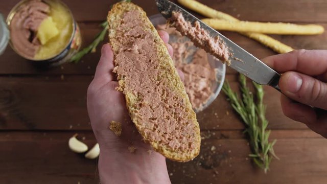 Cooking of delicious French Breakfast, spreading meat pate on bread in kitchen