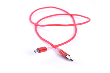Red USB cable for smartphone charge isolated on white background.