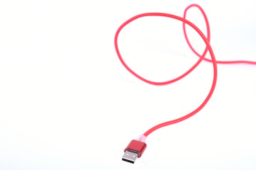 Red USB cable for smartphone charge isolated on white background.