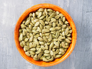 Spice green cardamom (Elettaria cardamomum) in a bamboo bowl. Modern apothecary, naturopathy and ayurveda concept