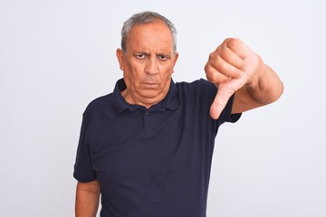 Senior grey-haired man wearing black casual polo standing over isolated white background looking unhappy and angry showing rejection and negative with thumbs down gesture. Bad expression.