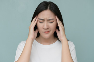 Exhausted Caucasian woman isolated on blue studio background touch massage temples suffer from strong migraine and fever.